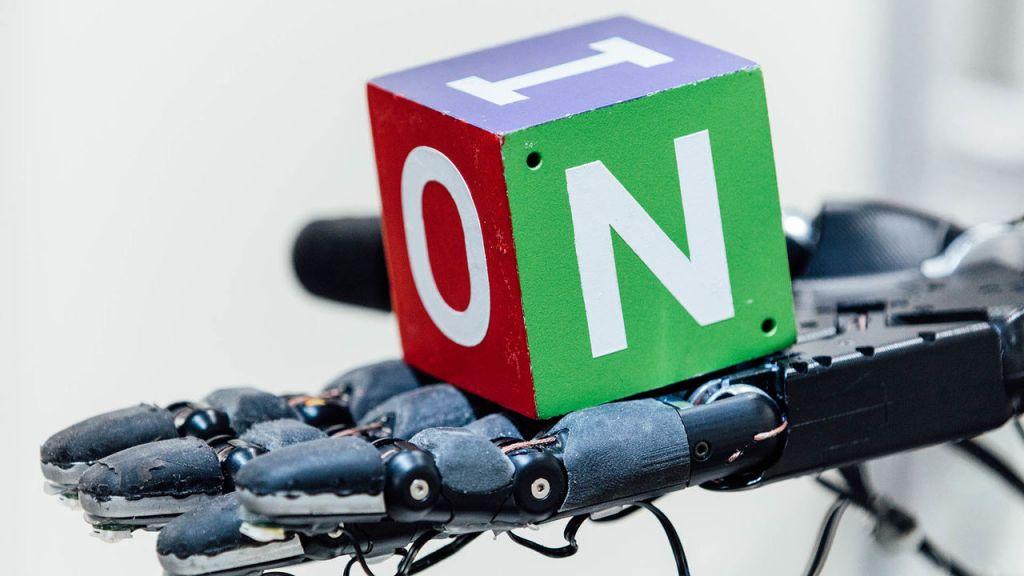 Ρομποτικό χέρι παίζει στα δάχτυλα έναν κύβο