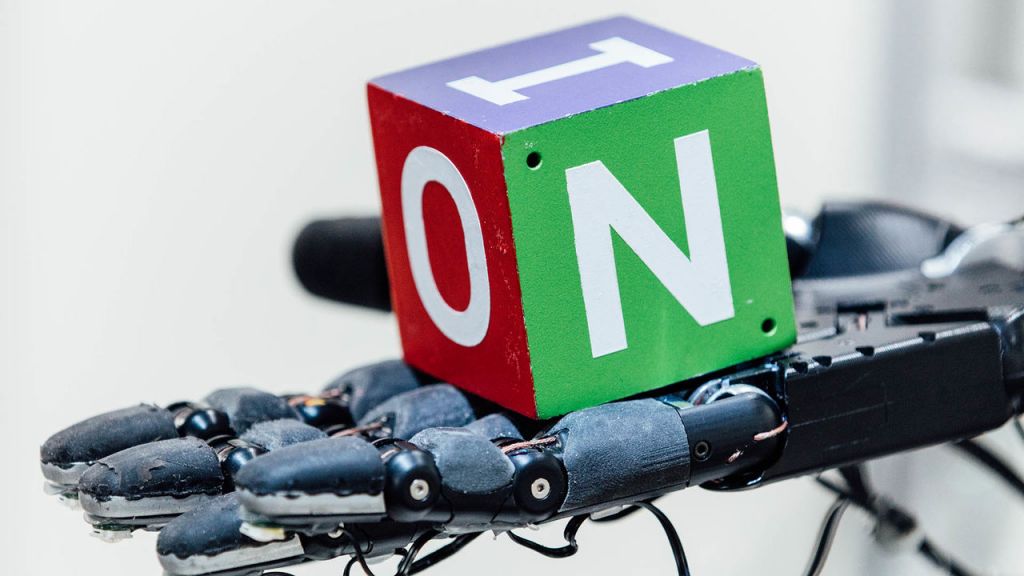 Ρομποτικό χέρι παίζει στα δάχτυλα έναν κύβο