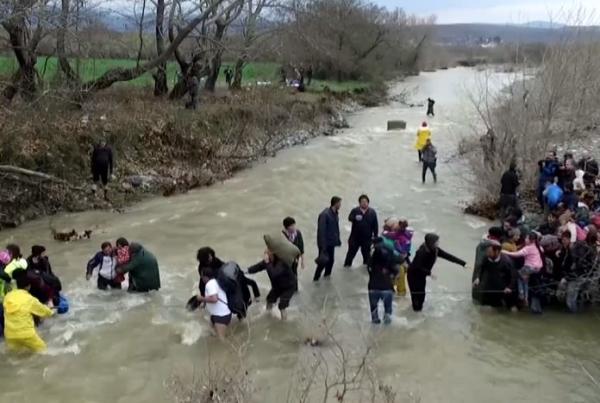 Πρόσφυγες περνούν χέρι-χέρι ποτάμι στην Ειδομένη (Εναέρια λήψη)