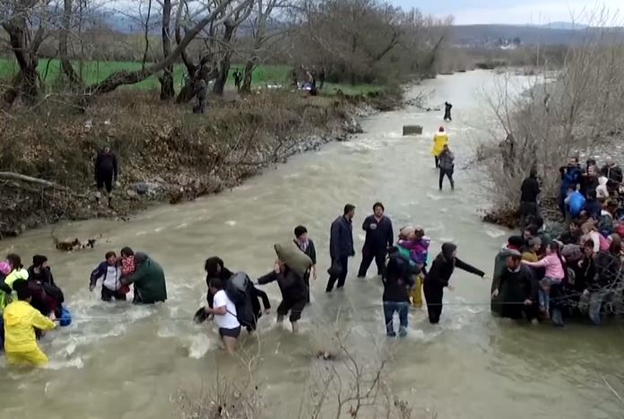 Πρόσφυγες περνούν χέρι-χέρι ποτάμι στην Ειδομένη (Εναέρια λήψη)