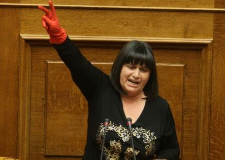 Με κόκκινο γάντι και το σήμα της νίκης απολυμένη καθαρίστρια στη Βουλή