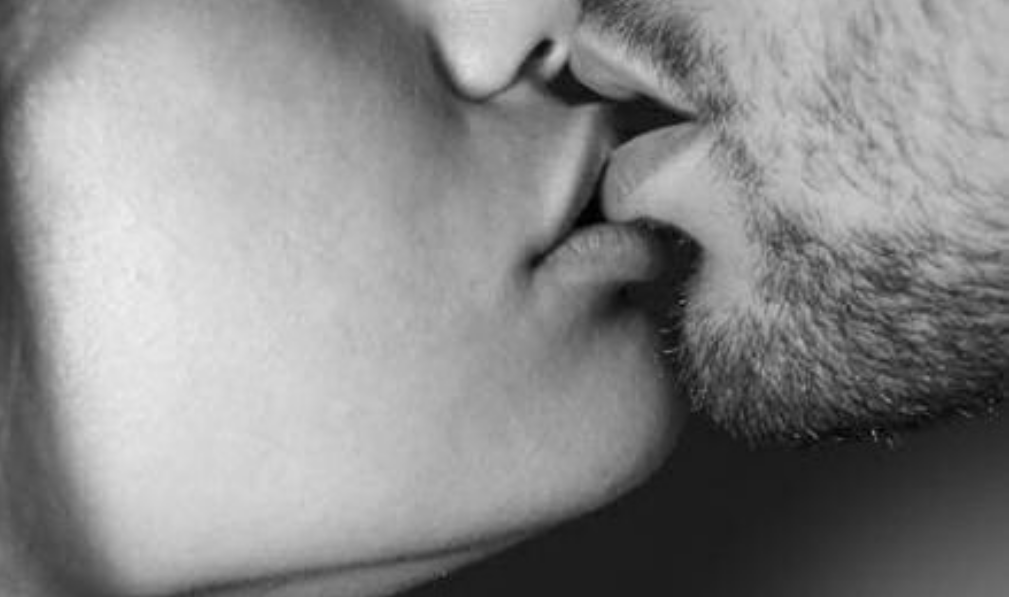 Мужчина кусает губы. Страстный поцелуй в губы. Поцелуй щетина. Страстный поцелуй с языком.