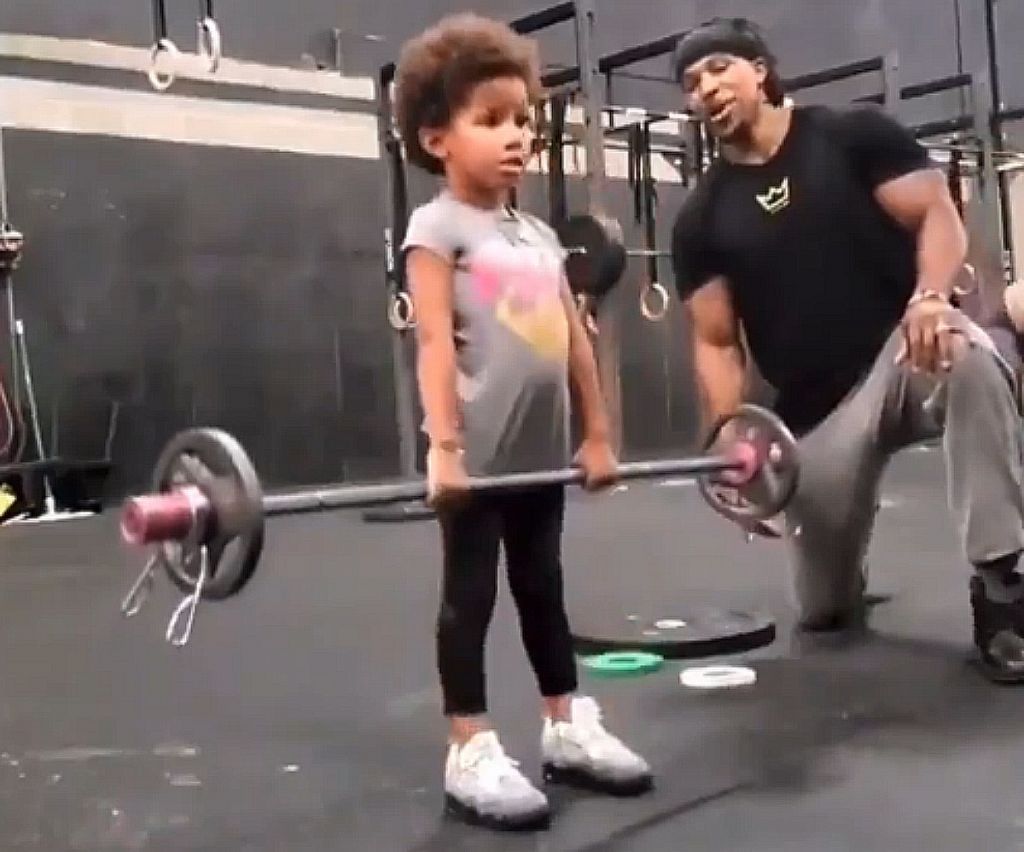 Κορίτσι σηκώνει βάρη έπειτα από ενθάρρυνση του πατέρα τηςl