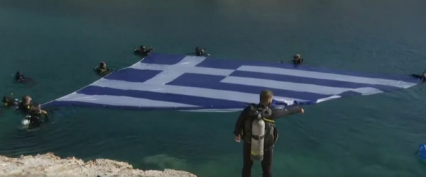Εντυπωσιακό βίντεο – Στη Βουλιαγμένη καταδύθηκε η μεγαλύτερη ελληνική σημαία