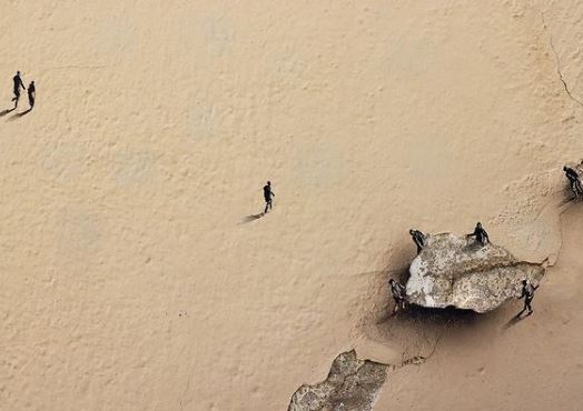 Μικρά ανθρωπάκια περπατούν σε φθαρμένους τοίχους της Μαδρίτης