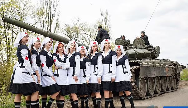 “Cheerleader” dell’invasione russa: indossano uniformi da infermiera con l’emblema “Z” e posano accanto a soldati e carri armati