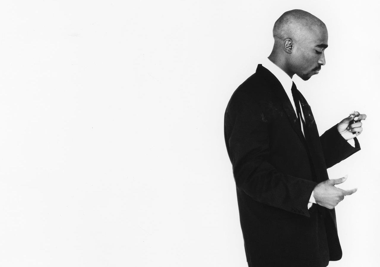 Αθλητικά παπούτσια συν παντελόνι κουστουμιού ισούνται με μια iconic φωτογράφιση του Tupac