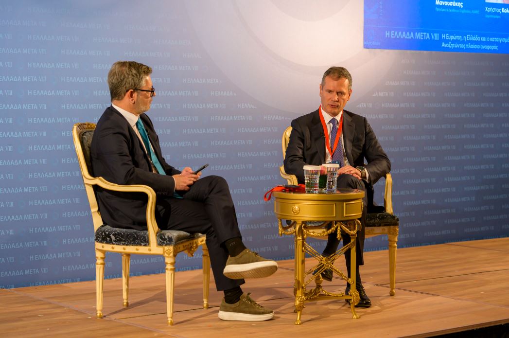 φωτογραφία όπου απεικονίζεται ο πρόεδρος και διευθύνων σύμβουλος του ΑΔΜΗΕ, Μανούσος Μανουσάκης, συνομιλεί με τον δημοσιογράφο του ΟΤ, Χρήστο Κολώνα