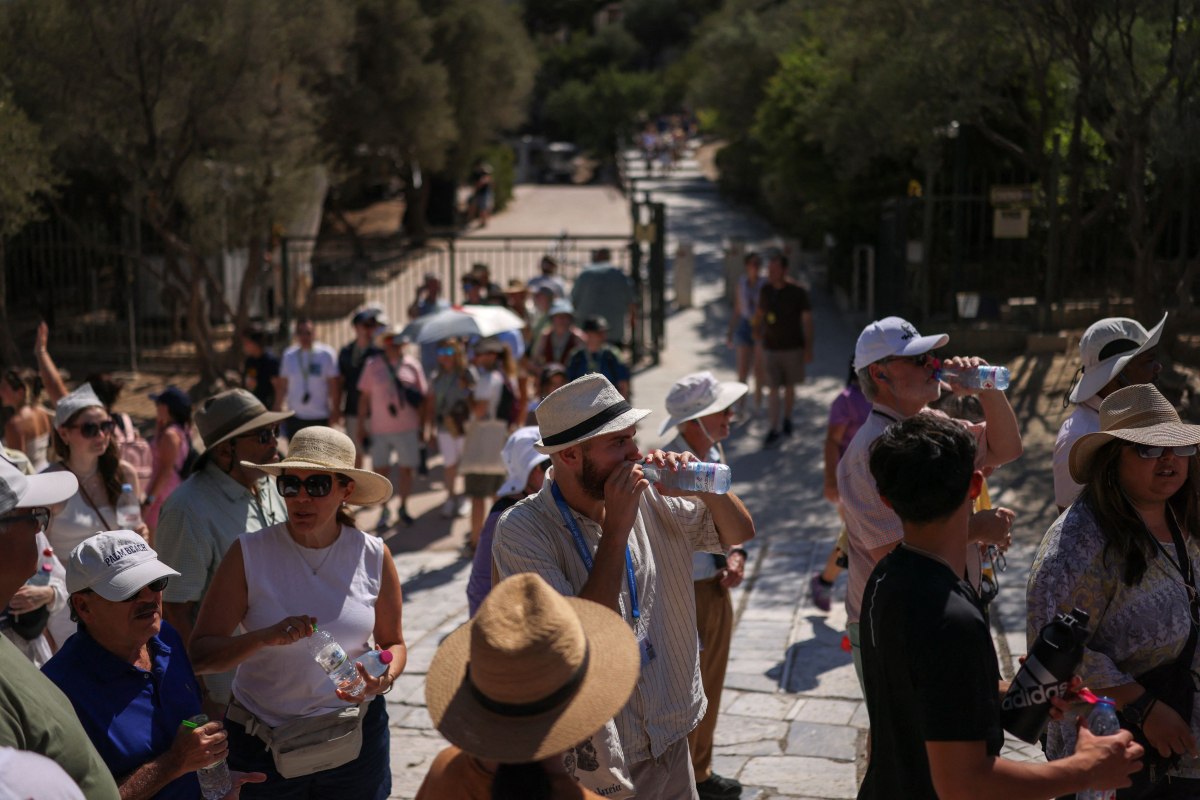 Τουρίστες περιμένουν έξω από την Ακρόπολη εν μέσω καύσωνα στις 9 Ιουλίου. Η ζέστη απειλεί τον τουρισμό (Reuters)