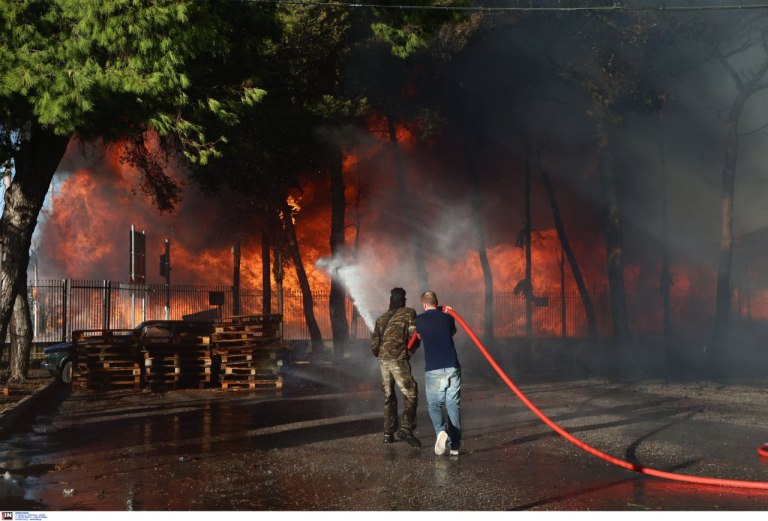 Σε εξέλιξη η μεγάλη φωτιά σε εργοστάσιο ξυλείας στις Αχαρνές – Επεκτάθηκε σε επιχείρηση υποδημάτων