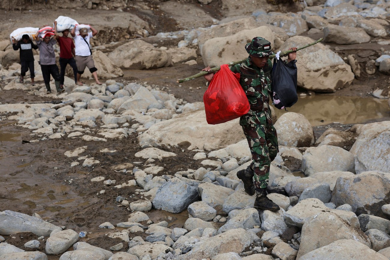 εικόνα που δείχνει έναν στρατιώτη μαζί με κατοίκους στη Δυτική Σουμάτρα να μεταφέρουν είδη πρώτης ανάγκης που θα διανεμηθούν σε πληγέντες