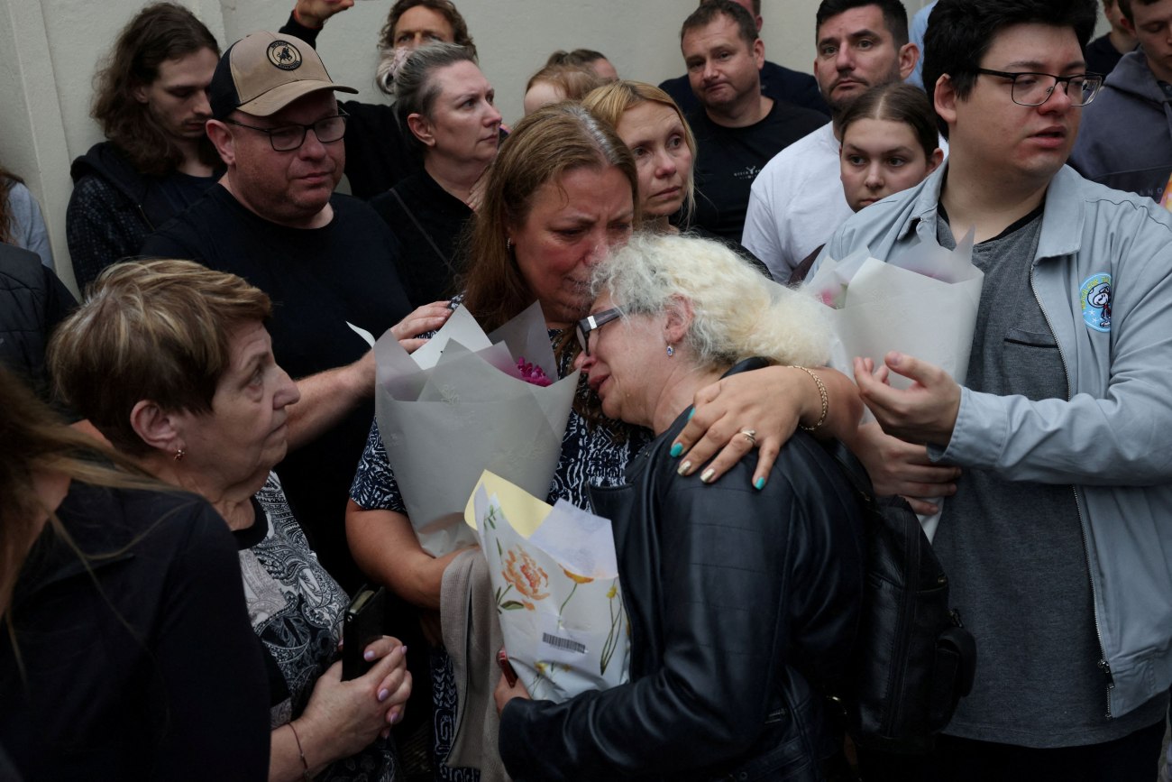 εικόνα που δείχνει συγγενείς των θυμάτων αφήνουν λουλούδια στο σημείο της τρομοκρατικής επίθεσης στην Αυστραλία