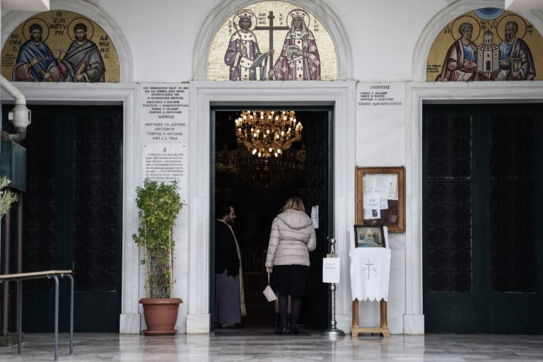 εικόνα που δείχνει πιστή να μπαίνει μέσα σε εκκλησία