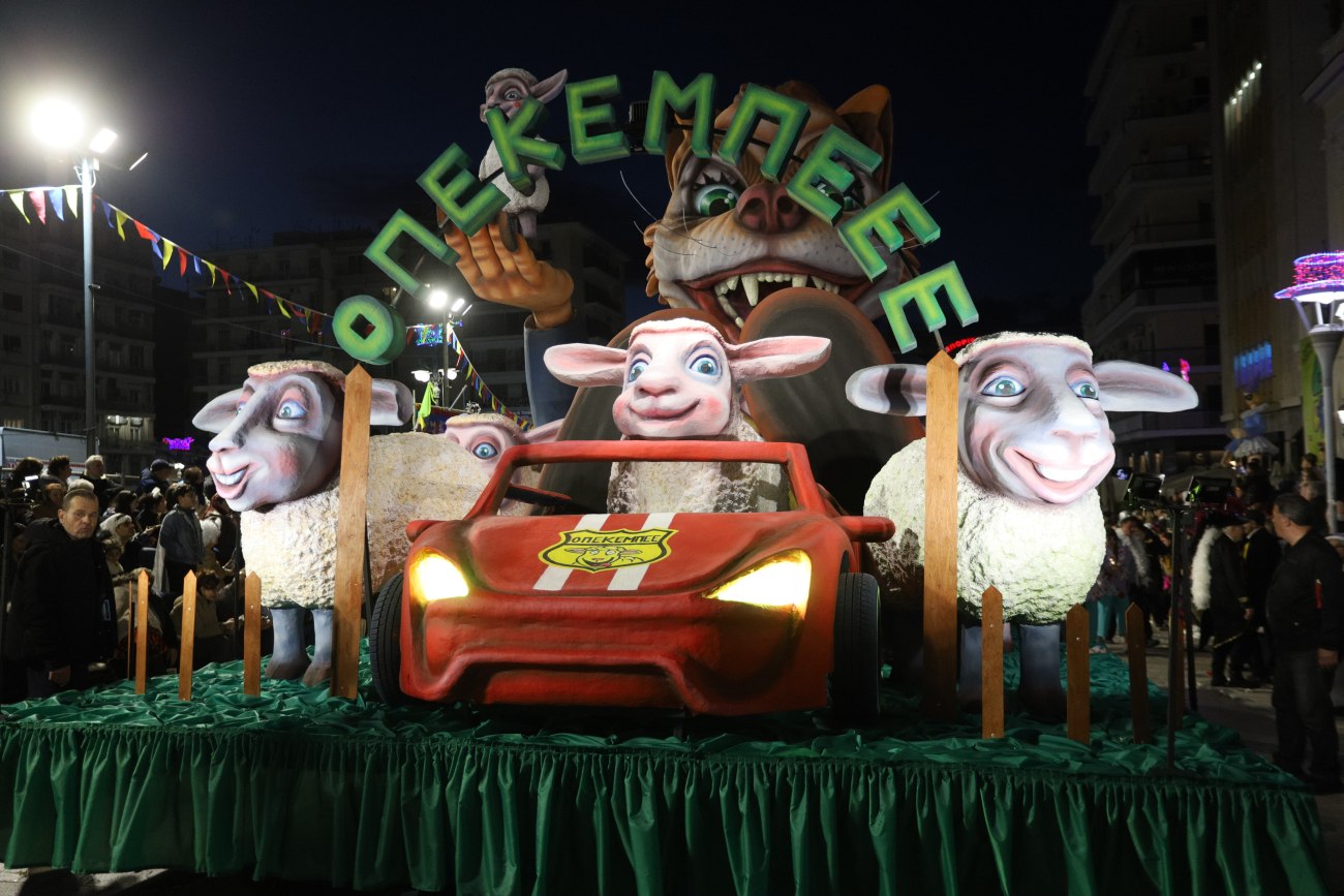 εικόνα που δείχνει το άρμα «ΟΠΕΚΕ Μπε…» ανάμεσα σε πολλά άλλα που πλαισιώνουν τους καρναβαλιστές 