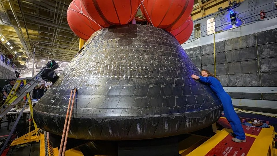 H Κριστίνα Κοχ της NASA, μέλος της αποστολής, αγκαλιάζει το Orion μετά τη φόρτωσή του σε πλοίο στον Ειρηνικό (Bill Ingalls/NASA)