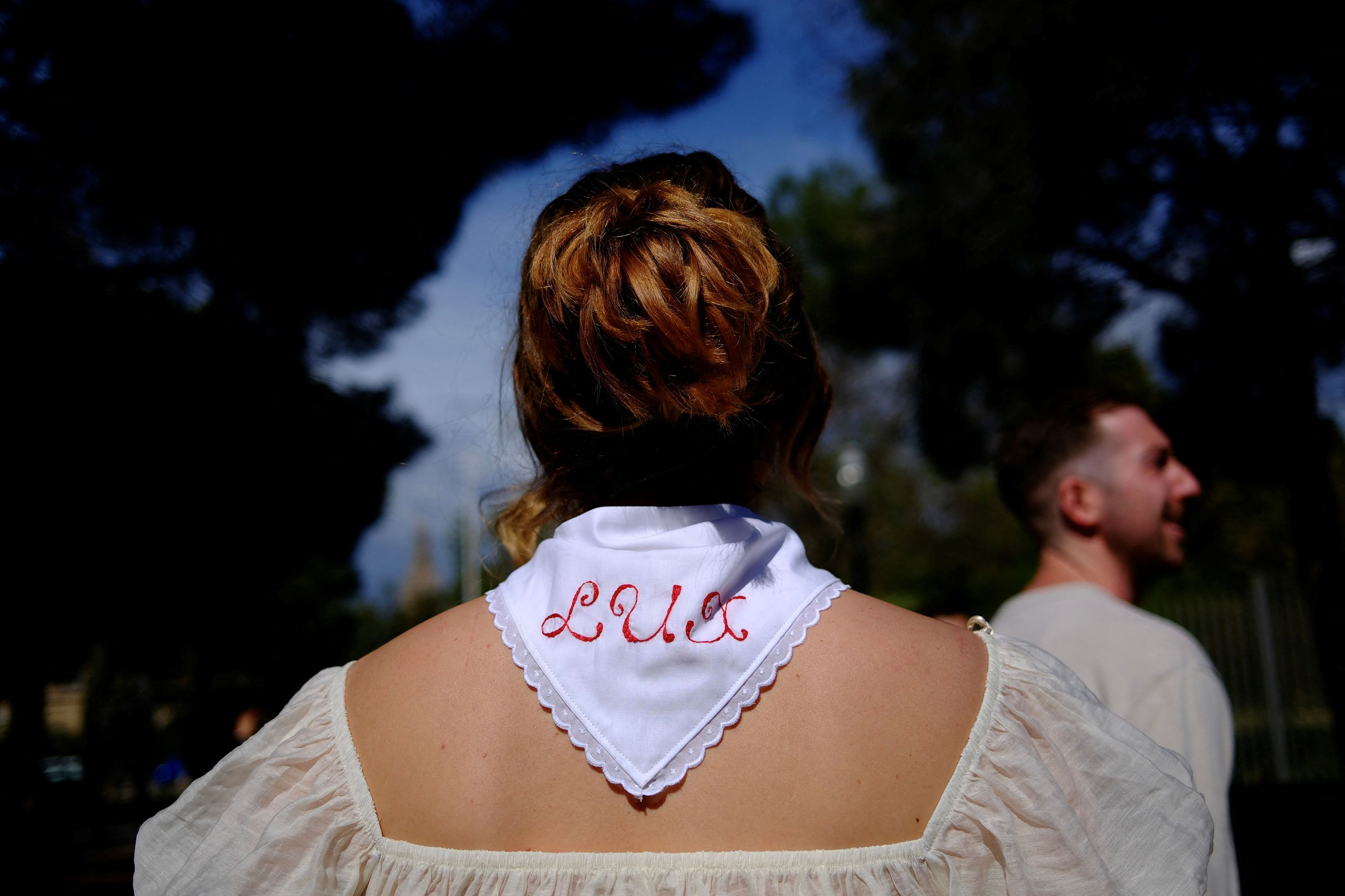 Γυναίκα φορά ένα φουλάρι με την επιγραφή «LUX», καθώς περιμένει στην ουρά για να δει την Rosalía, η οποία πρόκειται να δώσει την πρώτη από τις τέσσερις συναυλίες της στη γενέτειρά της, τη Βαρκελώνη, στο πλαίσιο της περιοδείας της «Lux», στην Ισπανία, 13 Απριλίου 2026. REUTERS/Nacho Doce