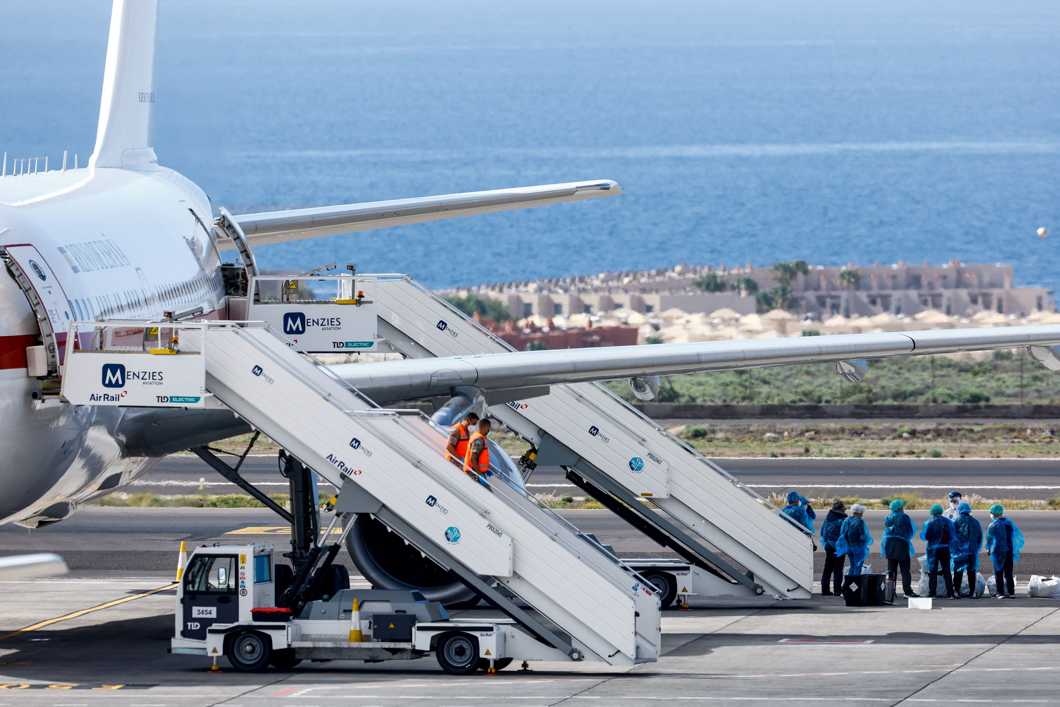 εικόνα που δείχνει επιβάτες του κρουαζιερόπλοιου MV Hondius όπου ξέσπασε χανταϊός να περιμένουν στον διάδρομο προσγείωσης του αεροδρομίου